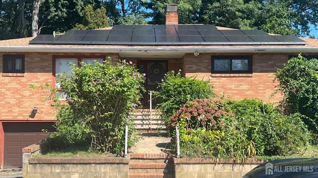 view of front of home with a chimney and brick siding