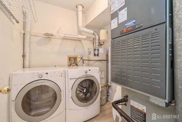52 Fair Acres Ct, South Brunswick, NJ 08540 - laundry area featuring washer and dryer, strapped water heater, light wood-style floors, and heating unit