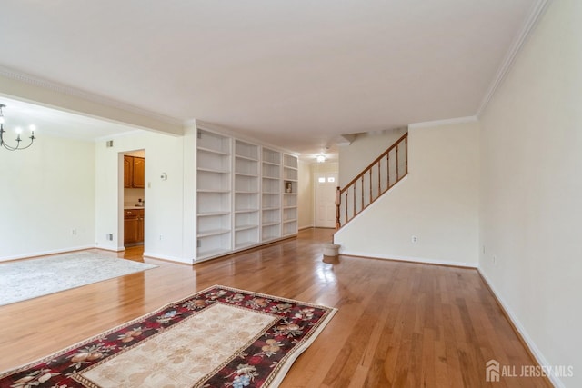 52 Fair Acres Ct, South Brunswick, NJ 08540 - unfurnished living room featuring ornamental molding, stairway, light wood-style flooring, and a chandelier