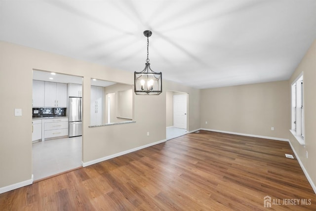 15 Betsy Ross Dr Unit B, Monroe, NJ 08831 - unfurnished dining area with a chandelier and light wood-style floors