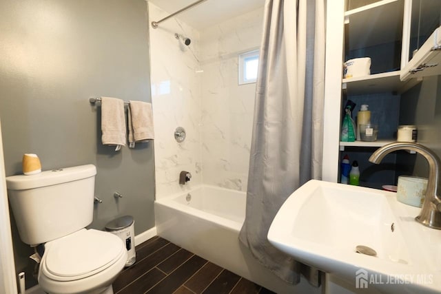 bathroom featuring a sink, toilet, shower / tub combo with curtain, wood finish floors, and baseboards