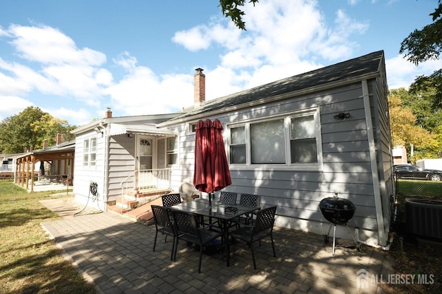 rear view of house featuring a patio area, a chimney, fence, and central AC unit