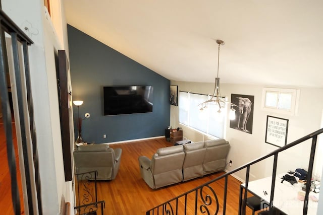 living area featuring lofted ceiling, an inviting chandelier, and wood finished floors