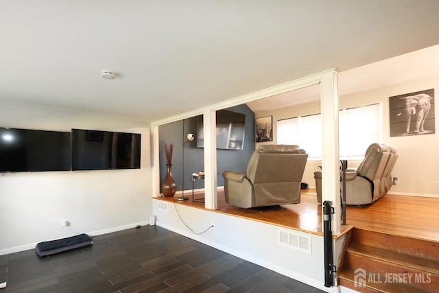 interior space featuring dark wood-type flooring, baseboards, and visible vents