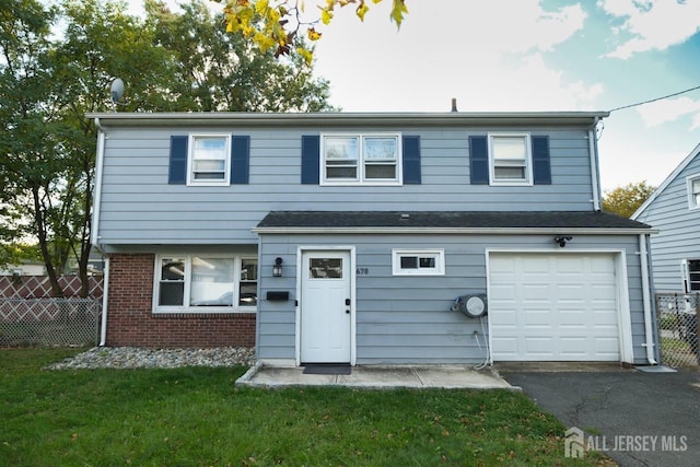 view of front facade with brick siding, fence, a garage, aphalt driveway, and a front lawn