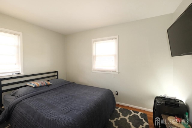 bedroom featuring wood finished floors and baseboards