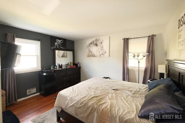 bedroom featuring visible vents, wood finished floors, and baseboards