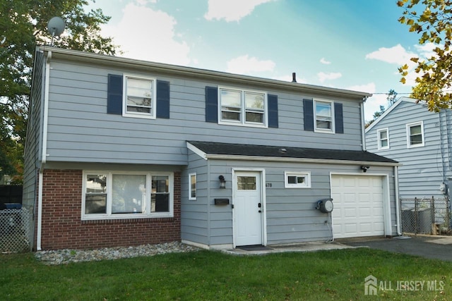 back of property featuring a garage, fence, aphalt driveway, a yard, and brick siding