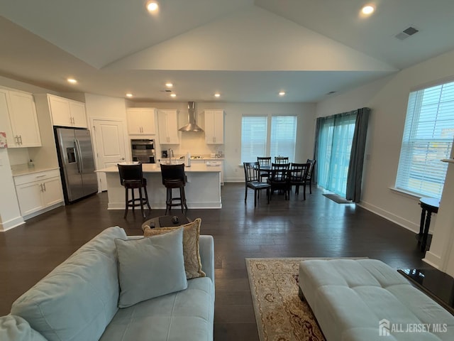 living room with visible vents, high vaulted ceiling, dark wood-style floors, recessed lighting, and baseboards