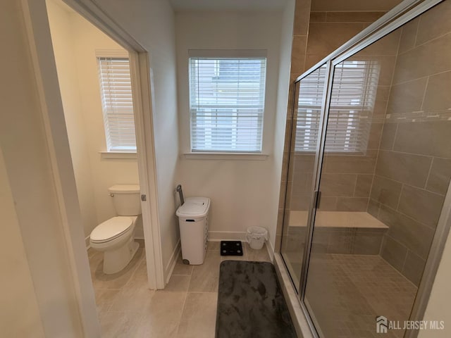 full bathroom featuring tile patterned floors, baseboards, toilet, and a stall shower