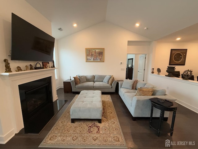 living room with visible vents, recessed lighting, lofted ceiling, and a glass covered fireplace