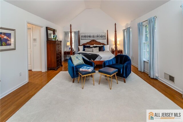 bedroom featuring hardwood / wood-style flooring and lofted ceiling