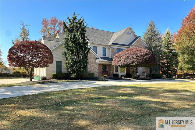 view of front of house featuring brick siding and a front yard