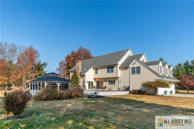 rear view of property with a gazebo and a yard