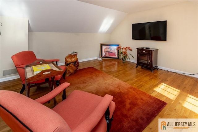 living room with lofted ceiling and hardwood / wood-style flooring