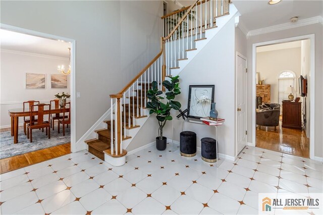 stairway with a fireplace, crown molding, a chandelier, baseboards, and tile patterned floors