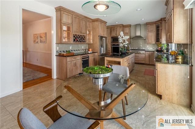 kitchen featuring tasteful backsplash, a center island, appliances with stainless steel finishes, beverage cooler, and wall chimney range hood