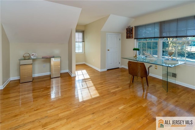 office featuring vaulted ceiling and light hardwood / wood-style floors