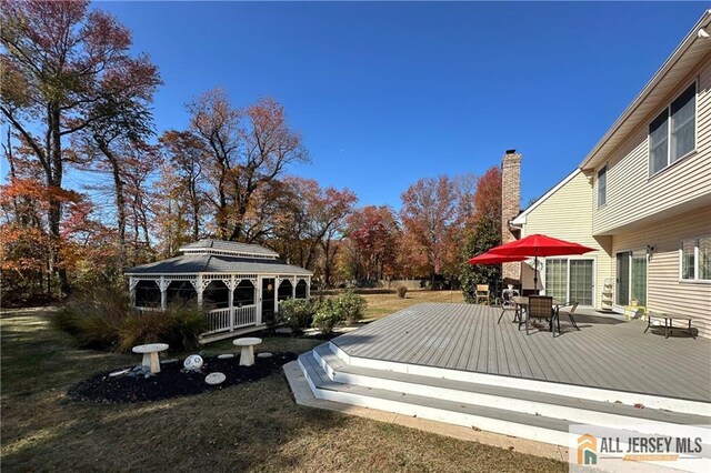 wooden deck featuring outdoor dining area and a gazebo