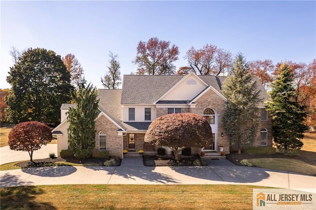 traditional-style house with a front yard and brick siding