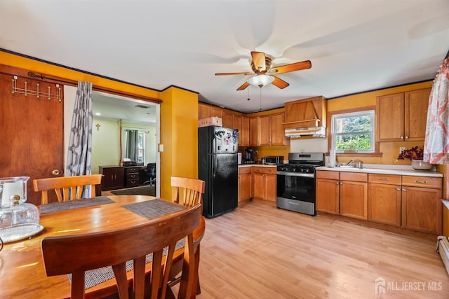 203 Lincoln Blvd, Middlesex, NJ 08846 - kitchen with stainless steel gas stove, freestanding refrigerator, under cabinet range hood, ceiling fan, and brown cabinetry