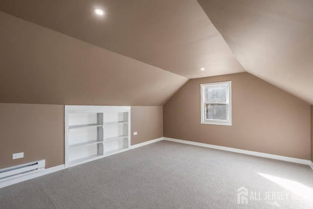 additional living space with a baseboard heating unit, carpet floors, built in features, and lofted ceiling