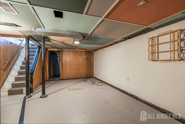 basement featuring wooden walls