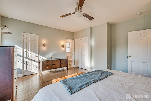 bedroom featuring a closet, ensuite bathroom, a ceiling fan, and wood finished floors