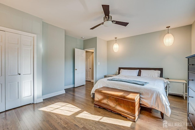 bedroom with a ceiling fan, baseboards, and wood finished floors