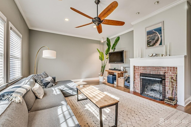 living area with a fireplace, crown molding, wood finished floors, and baseboards