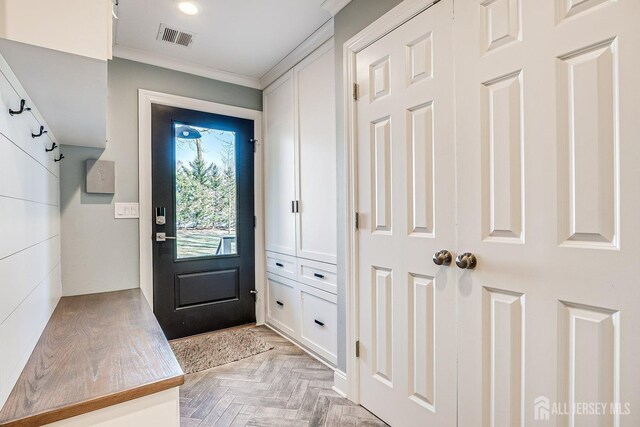 interior space featuring visible vents and crown molding