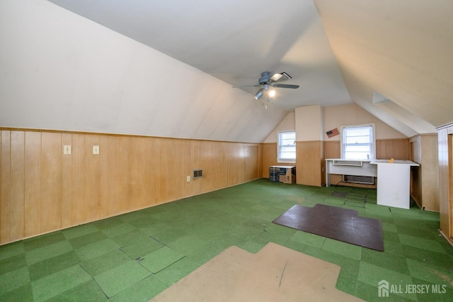 additional living space featuring wood walls, visible vents, ceiling fan, vaulted ceiling, and tile patterned floors