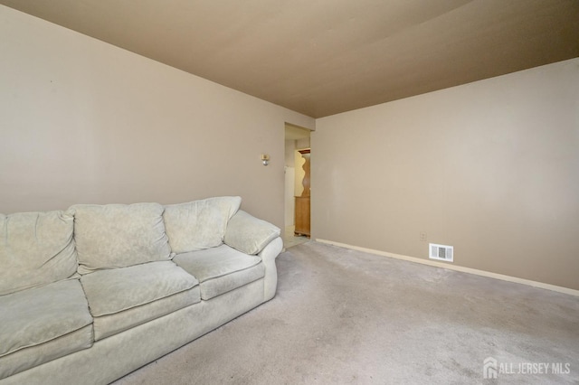 living room with carpet flooring, visible vents, and baseboards