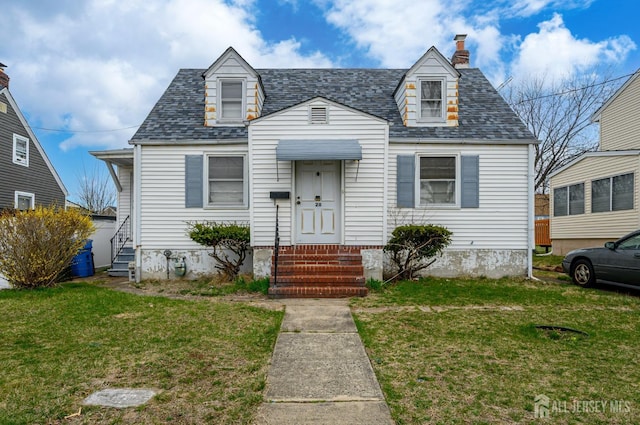 cape cod-style house featuring a front yard, roof with shingles, entry steps, and a chimney