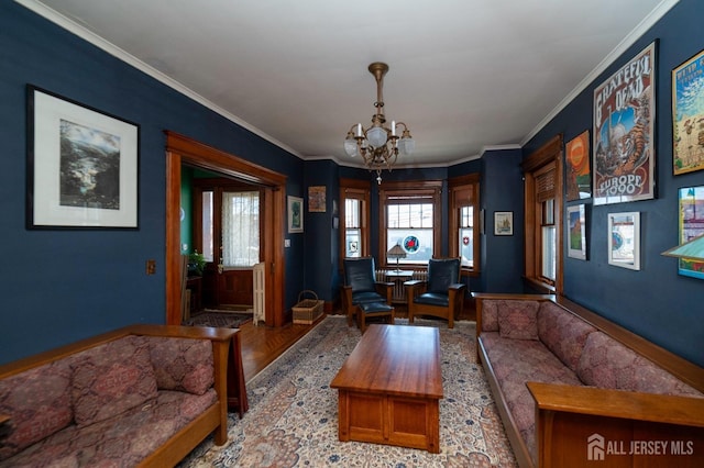 living area featuring ornamental molding, wood finished floors, and an inviting chandelier