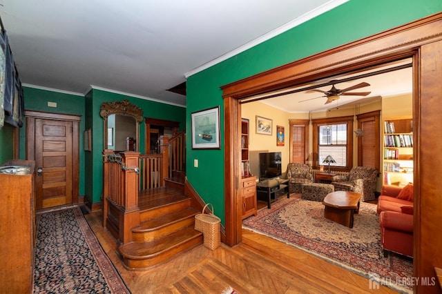 interior space with baseboards, a ceiling fan, stairway, wood finished floors, and crown molding