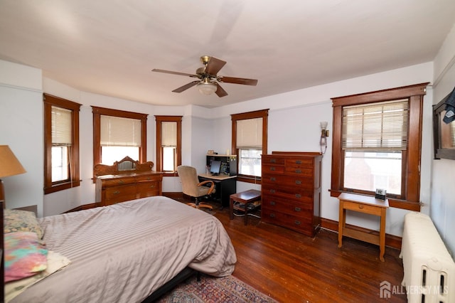 bedroom featuring baseboards, ceiling fan, wood finished floors, and radiator