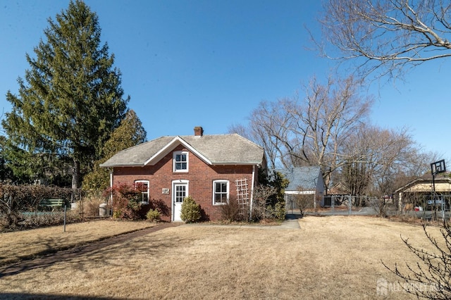 view of home's exterior featuring a yard, brick siding, fence, and a chimney