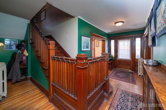 foyer entrance featuring stairway, baseboards, and wood finished floors