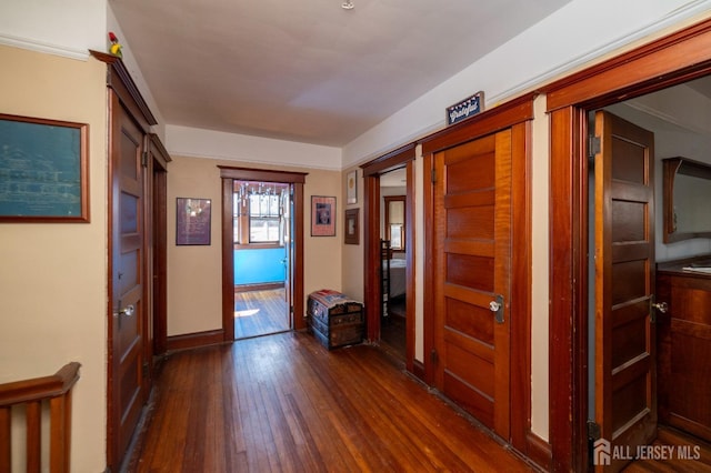 hall with dark wood-style floors and baseboards