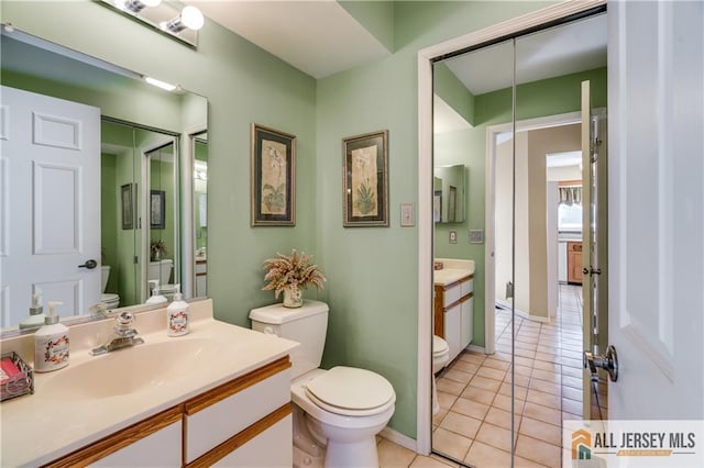 bathroom with vanity, toilet, and tile patterned floors