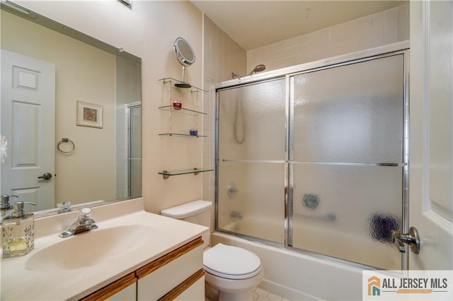 full bath with combined bath / shower with glass door, vanity, and toilet