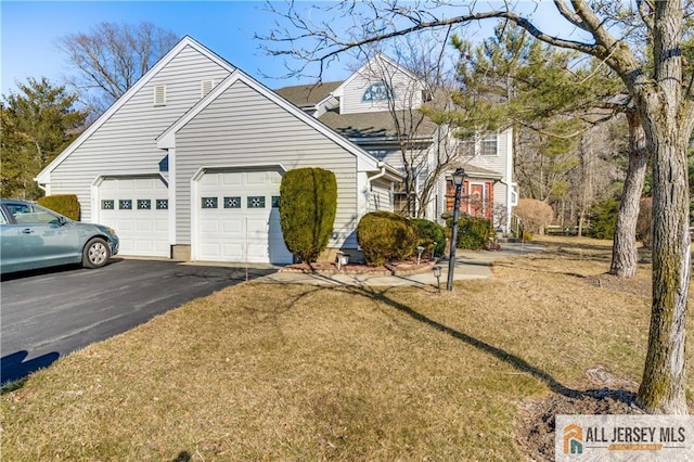 view of front of house featuring a garage, driveway, and a front yard