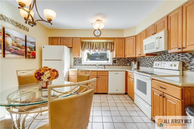 kitchen featuring light tile patterned floors, a chandelier, white appliances, light countertops, and tasteful backsplash