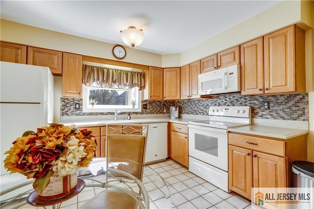 kitchen with a sink, light countertops, white appliances, and backsplash