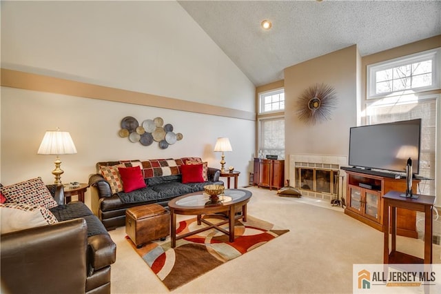 carpeted living area with a fireplace, high vaulted ceiling, and a textured ceiling