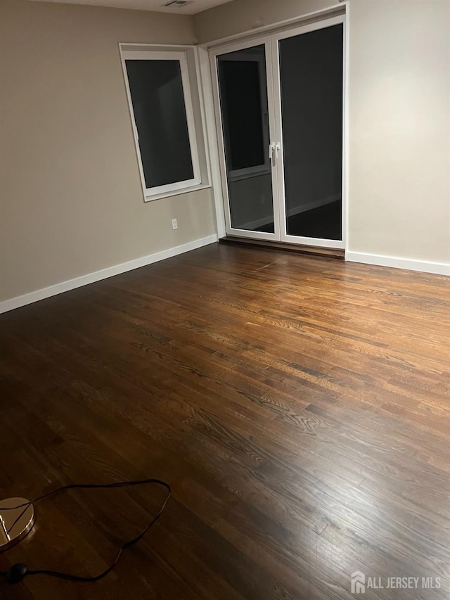 empty room with dark hardwood / wood-style floors