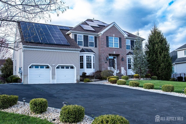 23 Keswick Cir, Monroe, NJ 08831 - view of front of house with driveway, roof mounted solar panels, and a front yard