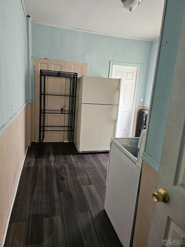 kitchen with white refrigerator, washer / dryer, and dark hardwood / wood-style flooring