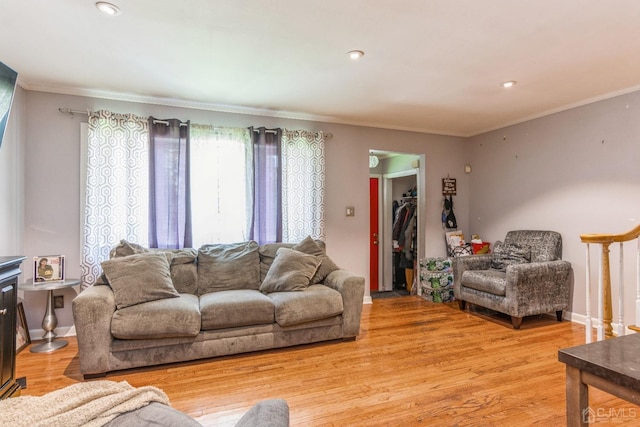 living room with ornamental molding, recessed lighting, light wood-style flooring, and baseboards